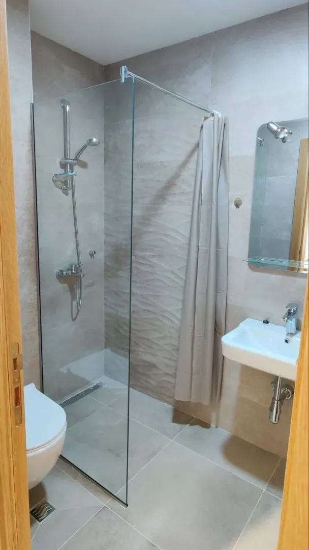 Manje kupatilo sa tuš kabinom, umivaonikom i WC šoljom.
