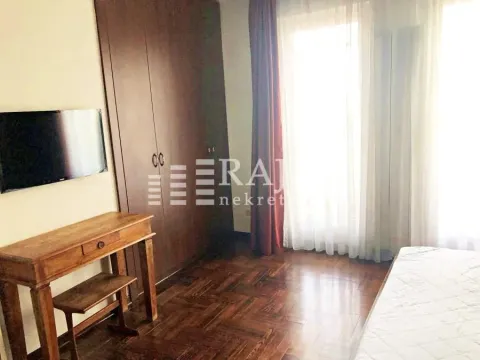 Furnished bedroom with a large wardrobe, double bed, desk, and television. - image 20