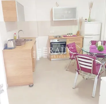 Small kitchen with a dining table and purple chairs. - image 6