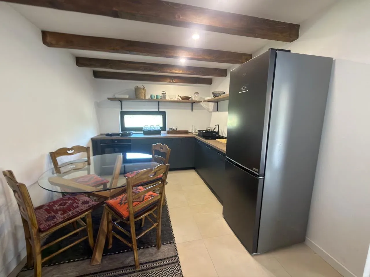 Kitchen with dining area and wooden ceiling beams.