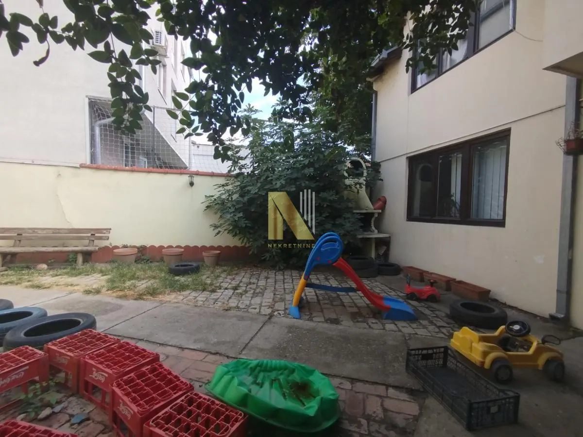 House yard with a paved area and children toys.