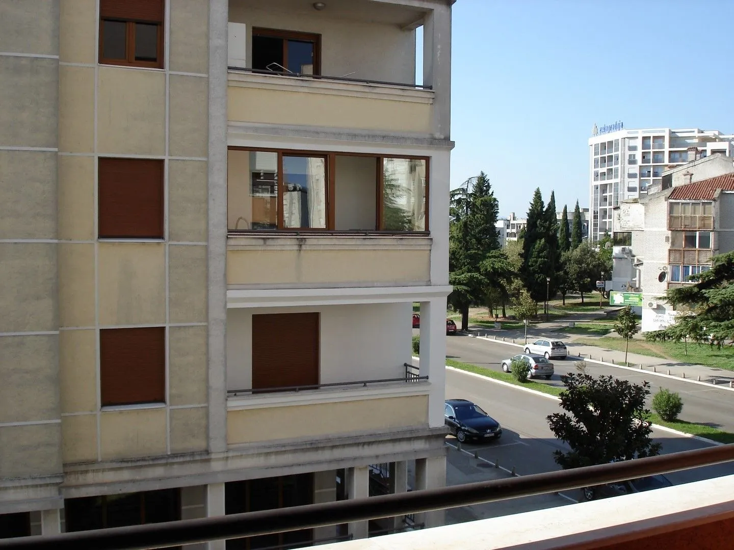 View from the terrace showing the neighboring building's facade and the street.