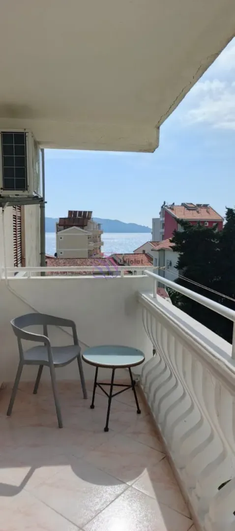 Manji namješteni balkon sa stolom, stolicom i pogledom na more.