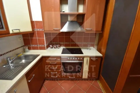 Kitchen equipped with wooden cabinets, a sink, and a built-in stove. - image 4