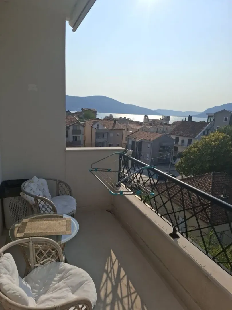 Namtještena terasa sa garniturom za sjedenje i pogledom na naselje i more.