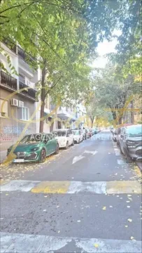 View of the street with parked cars and trees in front of the building. - image 7