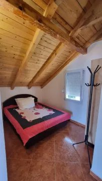 Manja spavaća soba sa bračnim krevetom i drvenim plafonom. - image 7