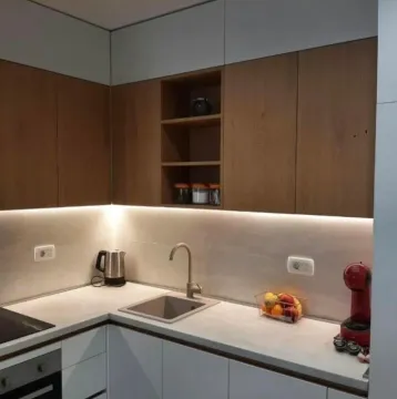 Modern kitchen with white and wood-finish cabinetry. - image 2