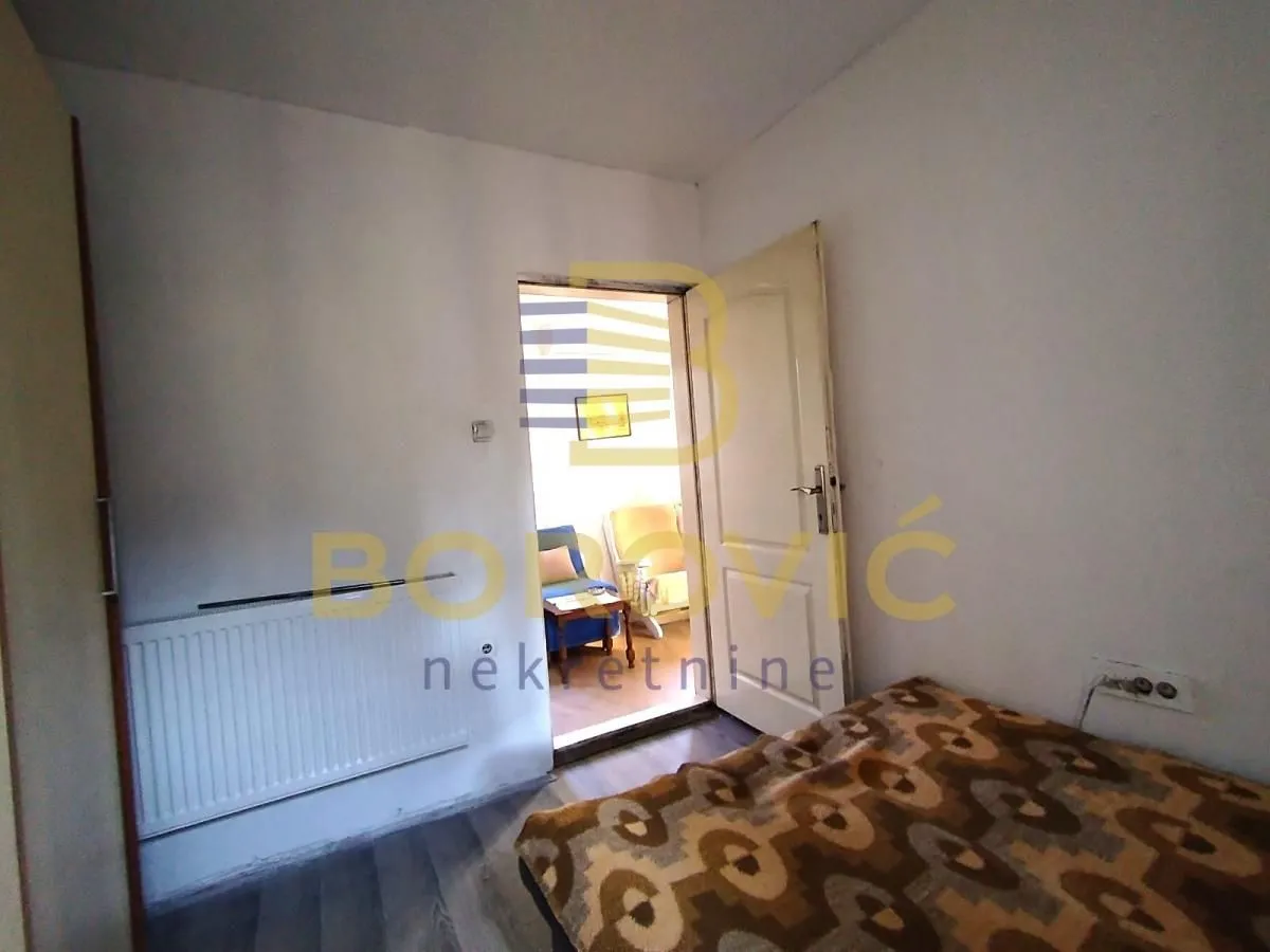 Small bedroom with a bed and a radiator.