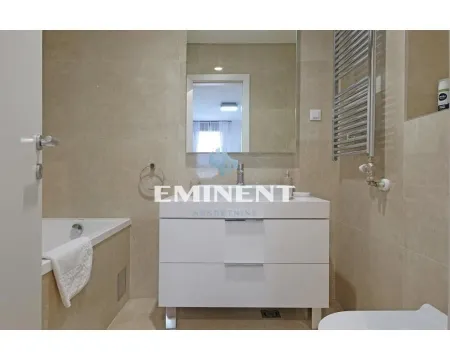 Modern bathroom with a vanity, mirror, and tiled bathtub. - image 14