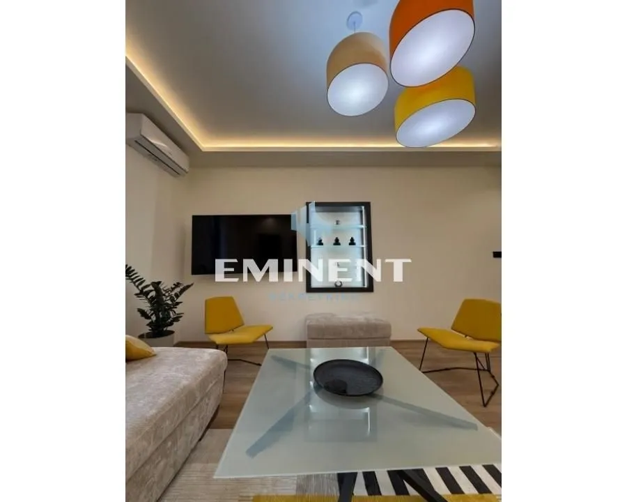 Living room with sofa, coffee table and modern lighting.