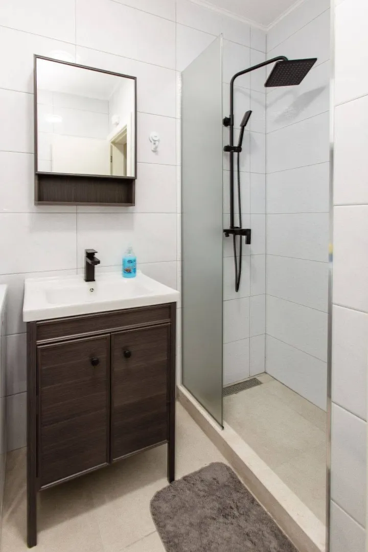Modernly equipped bathroom with a walk-in shower and vanity unit.