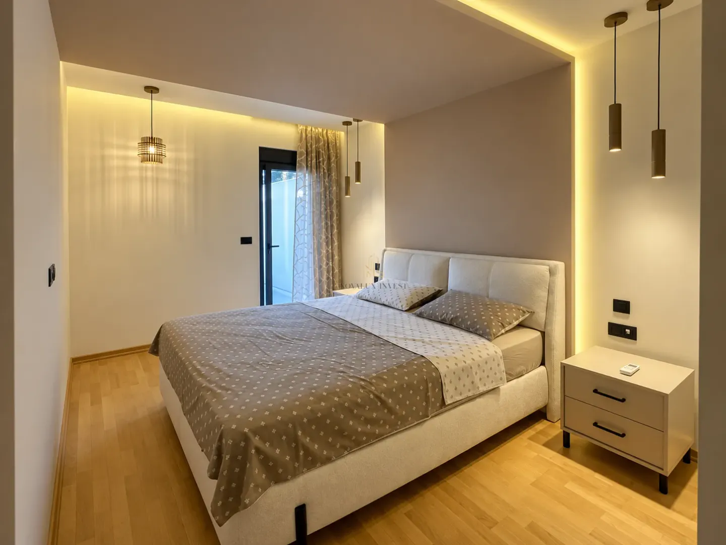Modern bedroom with a double bed, bedside tables, and built-in lighting.