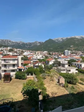 View from the terrace overlooking the town, green areas, and mountains in the background. - image 7
