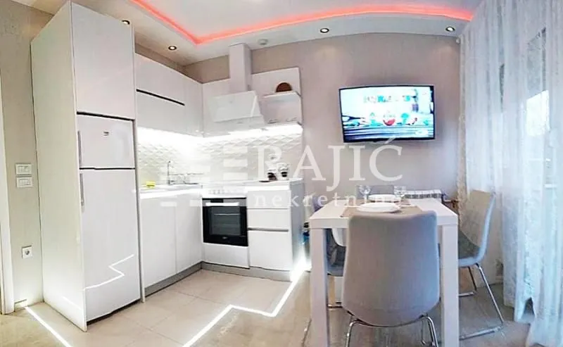 White kitchen with dining area and built-in appliances.