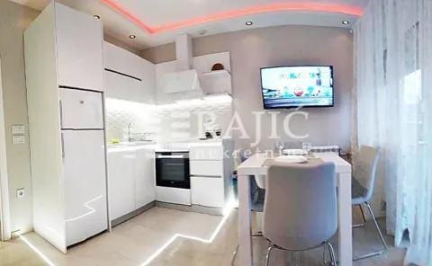White kitchen with dining area and built-in appliances. - image 7