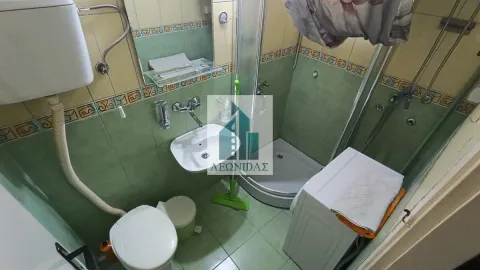 Small bathroom with a shower cabin, washbasin, toilet, and washing machine. - image 10