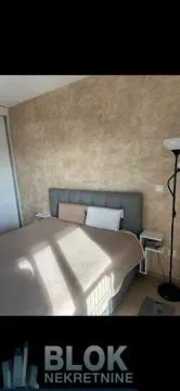 Pogled na spavaću sobu sa bračnim krevetom i dekorativnim zidom. - image 3