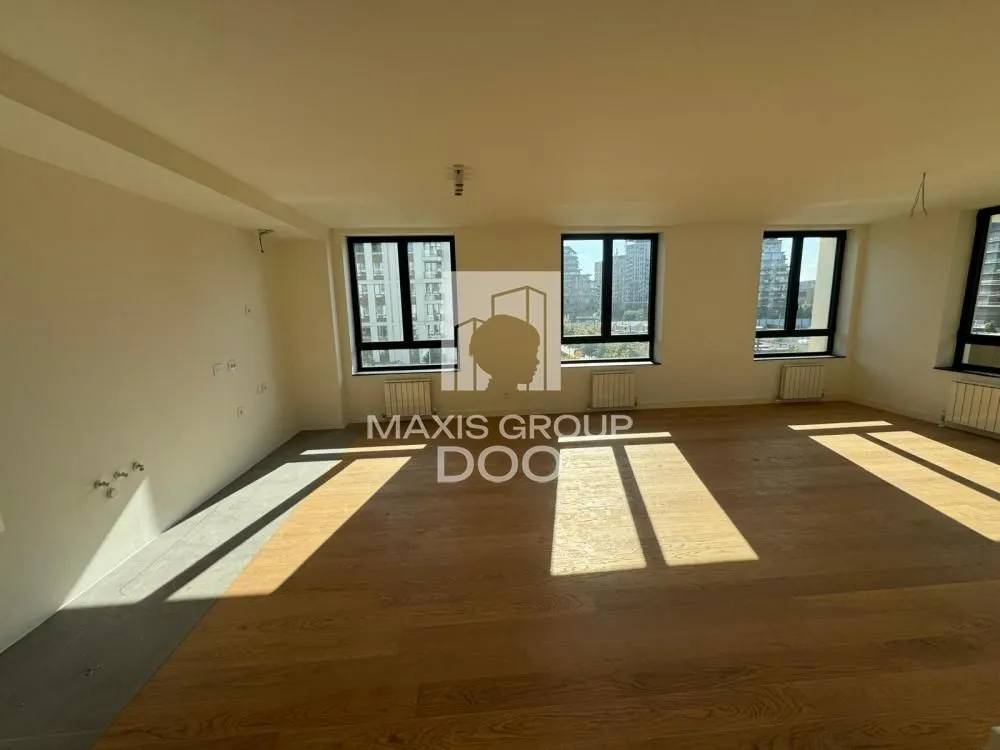 Spacious unfurnished room with wooden flooring and large windows.