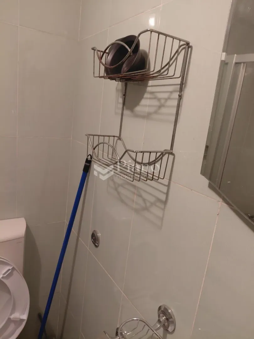 View of the bathroom with wall shelves and a mirror.