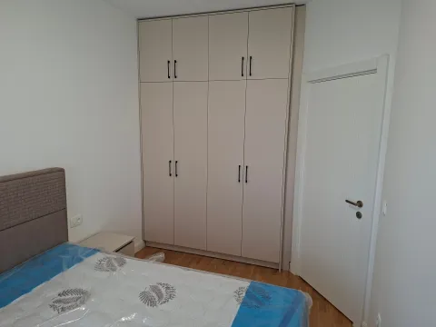 Bedroom with a double bed, large built-in wardrobe, and a white door. - image 11
