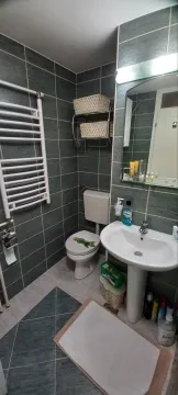 Kupatilo opremljeno umivaonikom, WC šoljom, ogledalom i radijatorom za peškire. - image 9