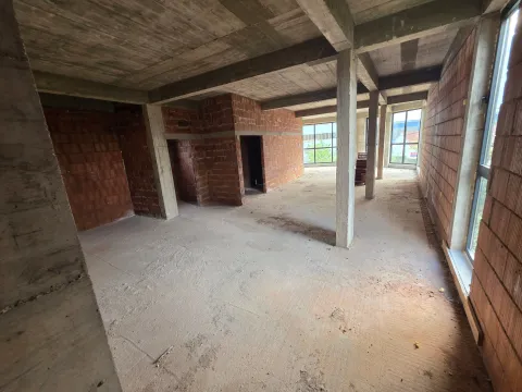 View of an unfinished space under construction with concrete pillars and brick walls. - image 5