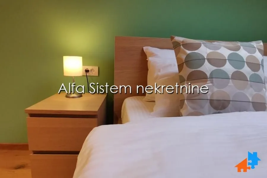 Spavaća soba sa krevetom i noćnim stočićem.