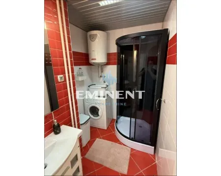 Bathroom with a shower cabin, washbasin, washing machine, and water heater. - image 15