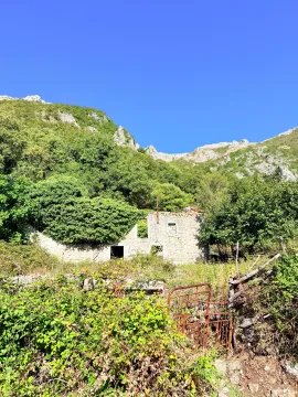 Ruševna kamena kuća u prirodi okružena zelenilom i brdima. - image 12