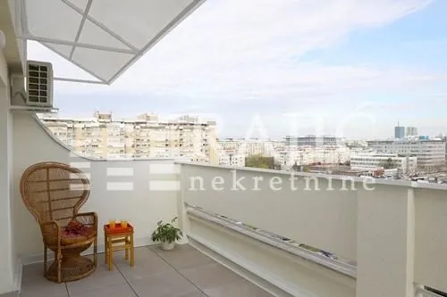 Spacious balcony with seating furniture and a city view.