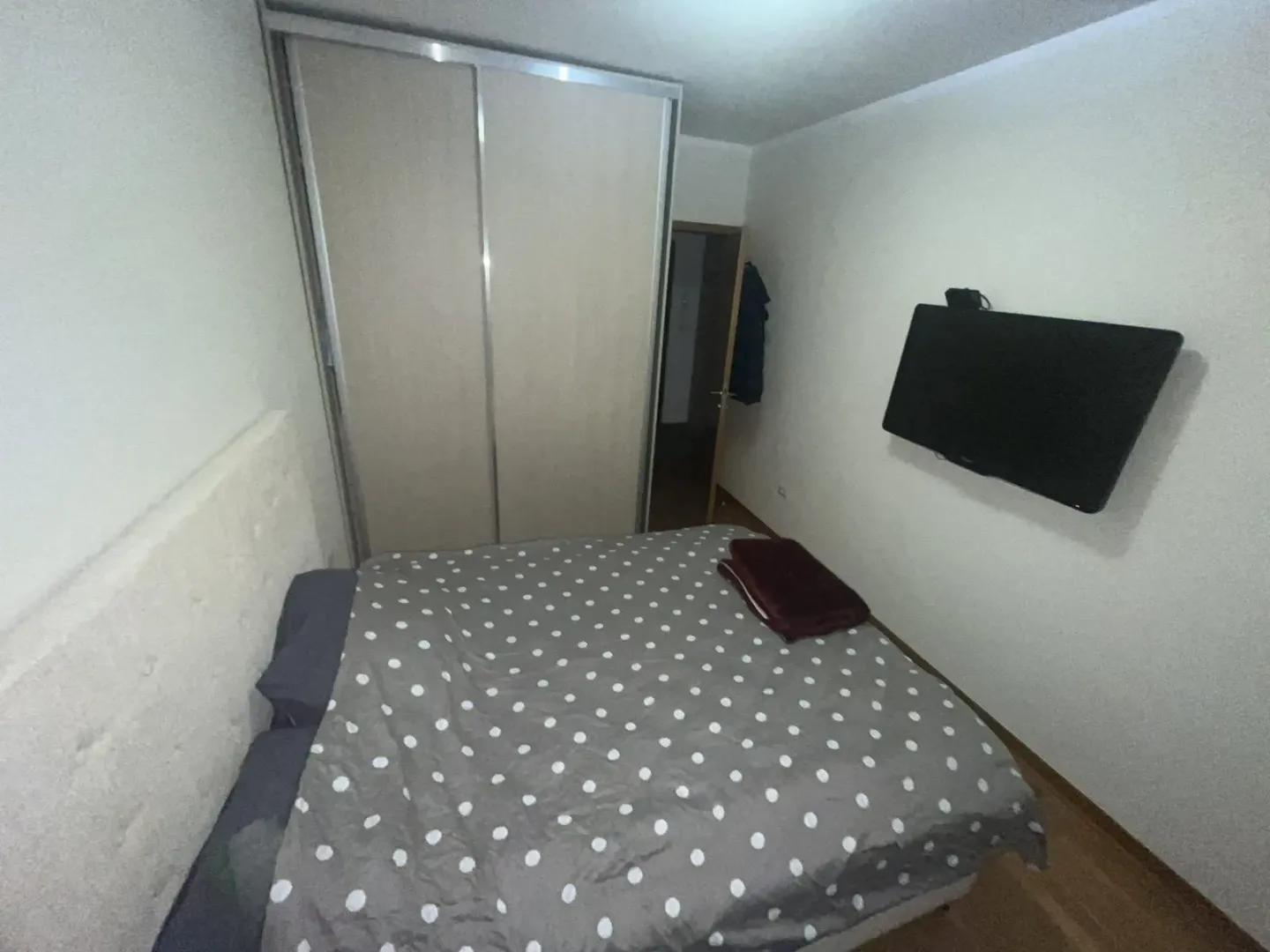 A bedroom with a double bed and a TV.