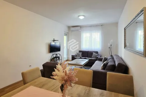 Dnevna soba sa garniturom, TV-om i trpezarijskim stolom u prvom planu. - image 15