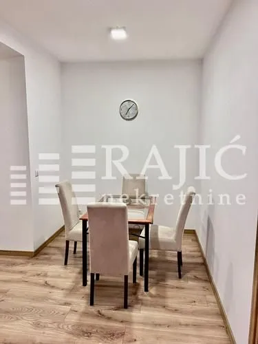 Dining area with a table and four chairs in bright tones.