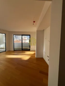 Prazna dnevna soba sa drvenim podom i izlazom na terasu. - image 4