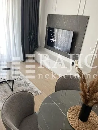 Modern living room with a dining table and a TV panel.