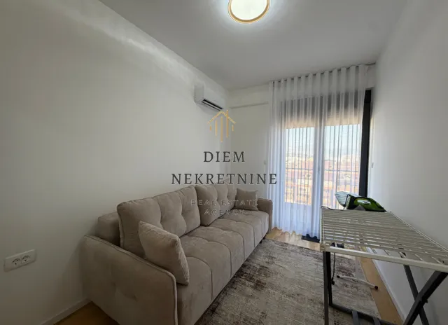 Small living room with a sofa and a clothes drying rack.