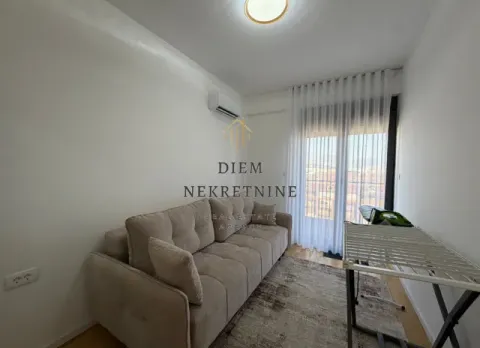 Small living room with a sofa and a clothes drying rack. - image 11