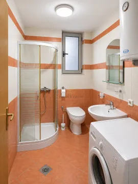 Kupatilo opremljeno tuš kabinom, umivaonikom, wc šoljom i veš mašinom. - image 5