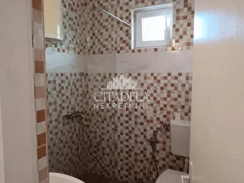 Kupatilo obloženo keramičkim pločicama sa tuš kabinom i toaletom. - image 8