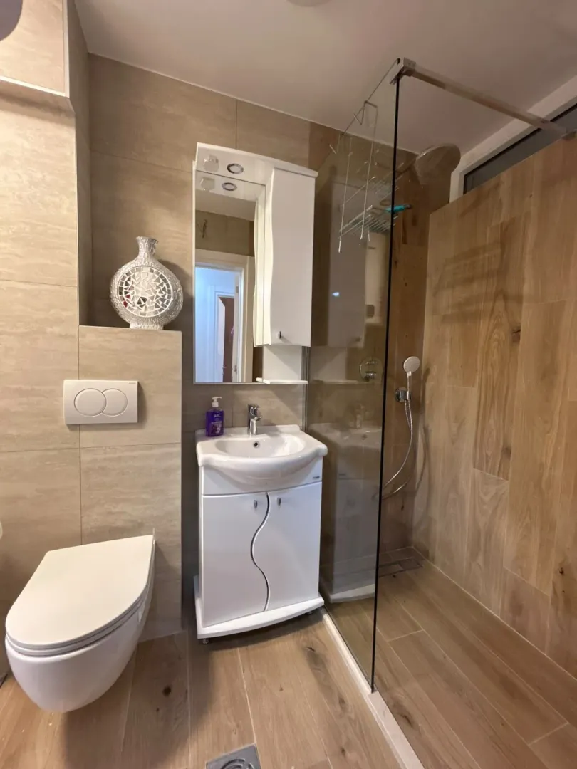 Modernly equipped bathroom with a walk-in shower, washbasin, and wall-hung toilet.