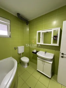 Bathroom with a bathtub, washbasin, and toilet in green tones. - image 13