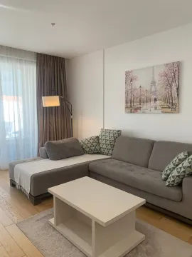 Dnevna soba sa ugaonom garniturom, stočićem i dekorativnom slikom na zidu. - image 3