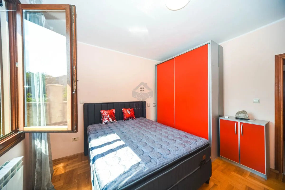 Bedroom with a double bed, large wardrobe, and an open window.