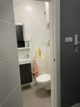 Pogled iz hodnika na manje kupatilo sa sanitarijama i belim pločicama. - image 14