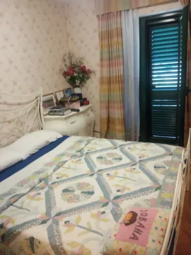 Bedroom with a metal bed, chest of drawers, and balcony access. - image 8