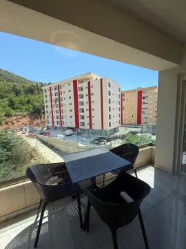 Terasa sa stolom i stolicama sa koje se pruža pogled na okolne zgrade. - image 7
