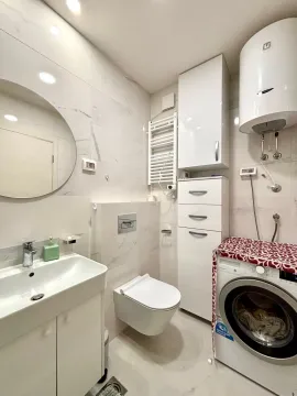 Moderno opremljeno kupatilo sa bijelim elementima, veš mašinom i ugradnim bojlerom. - image 7