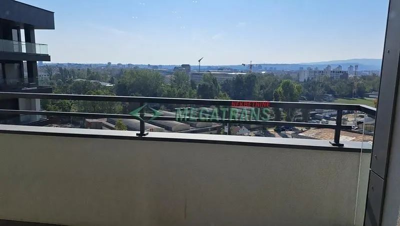 Pogled sa balkona na okolno zelenilo i grad.