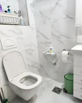Moderno i svetlo uređeno kupatilo sa belim mermernim pločicama i wc šoljom. - image 8